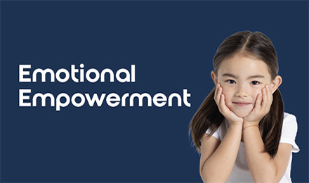 Smiling child with long dark hair poses with hands on cheeks in front of a navy background, next to the phrase 'Emotional Empowerment,' supporting kids’ mental health and self-awareness.